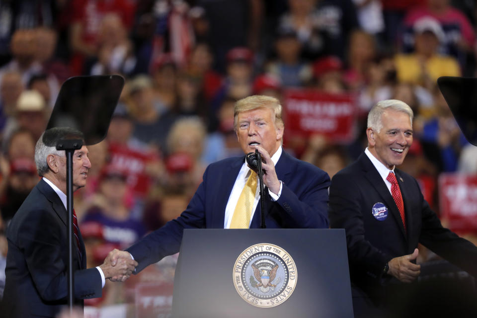 President Donald Trump greets Louisiana Republican gubernatorial candidates Ralph Abraham right, and Eddie Rispone at Trump's campaign rally in Lake Charles, La., Friday, Oct. 11, 2019. Trump introduced both on the eve of the Louisiana election, urging the crowd to vote for either to unseat incumbent Democrat Gov. John Bel Edwards. (AP Photo/Gerald Herbert)