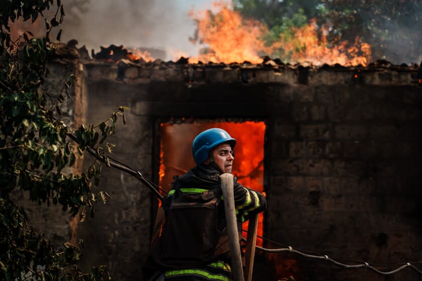 LYSYCHANSK, UKRAINE -- JUNE 11, 2022: A firefighter waits for his engine truck to resume water pressure so that they can put out a house that caught fire after a bombardment landed in a residential neighborhood in Lysychansk, Ukraine, Saturday June 11, 2022. (Marcus Yam / Los Angeles Times)
