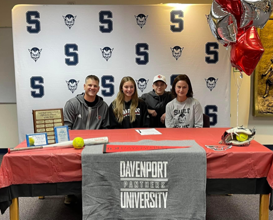 Sault High athlete Hannah Maurer gets ready to sign her National Letter of Intent to play softball at Davenport University.  She is surrounded by her family as she prepares to put ink to paper.