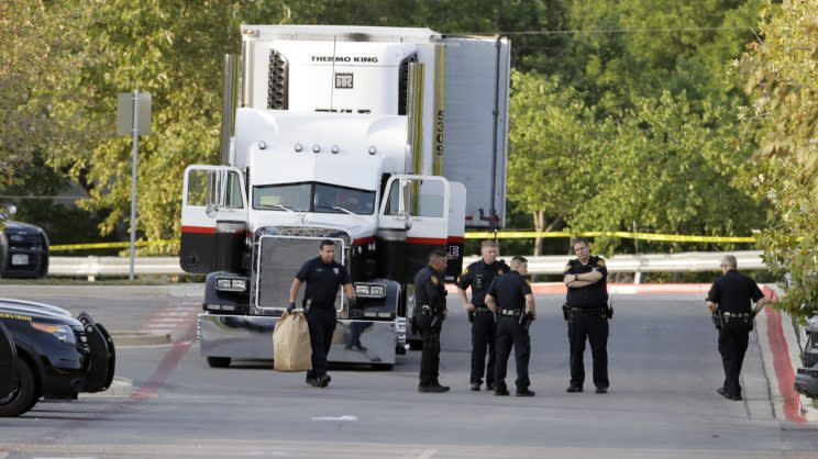 Varios policías junto al remolque donde fueron halladas ocho personas muertas y al menos 30 sobrevivientes en el estacionamiento de una tienda Walmart en San Antonio, el domingo 23 de julio de 2017. (AP Foto/Eric Gay)