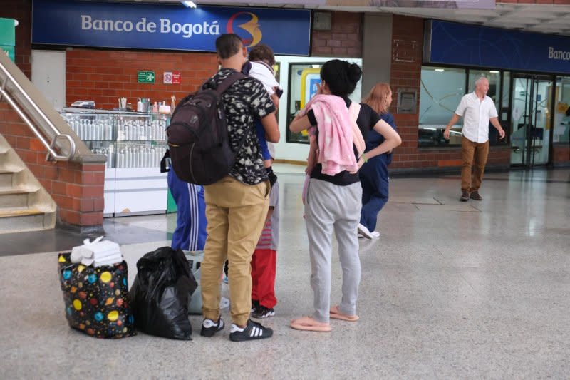 Groups of migrants wait for buses in Medellin, Colombia, for a trip to the northwest coastal cities of Turbo or Necocli, where the journey begins through the Darien Gap. Photo by Austin Landis/UPI