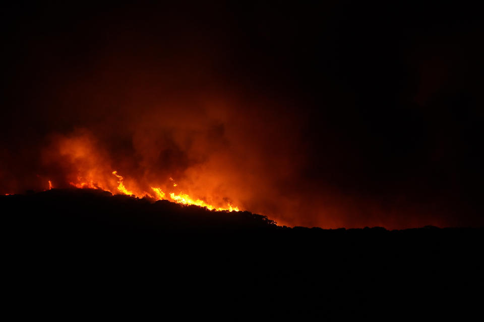 Fires rage through the countryside in Cuglieri, near Oristano, Sardinia, Italy, early Sunday, July 25, 2021. Hundreds of people were evacuated from their homes in many small towns in the province of Oristano, Sardinia, after raging fires burst in the areas of Montiferru and Bonarcado. (Alessandro Tocco/LaPresse via AP)