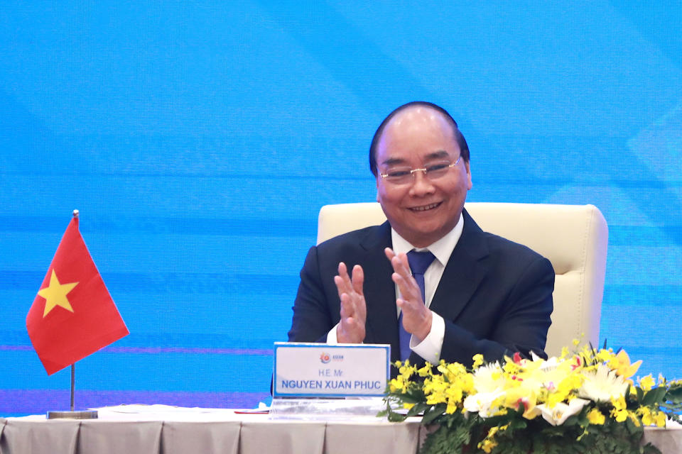 Vietnamese Prime Minister Nguyen Xuan Phuc applauds during a virtual signing ceremony of the Regional Comprehensive Economic Partnership, or RCEP, trade agreement in Hanoi, Vietnam on Sunday, Nov. 15, 2020. China and 14 other countries agreed Sunday to set up the world’s largest trading bloc, encompassing nearly a third of all economic activity, in a deal many in Asia are hoping will help hasten a recovery from the shocks of the pandemic.(AP Photo/Hau Dinh)