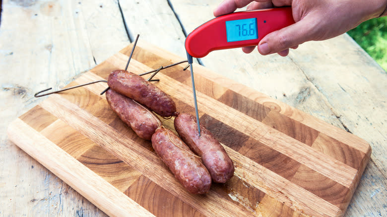 thermometer checking temperature of sausages