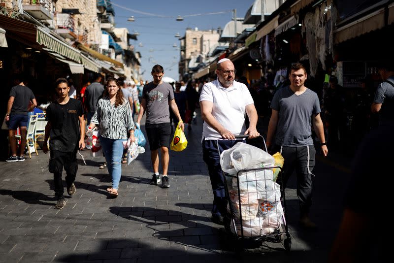 Shoppers carry their groceries through Mahane Yehuda market in Jerusalem