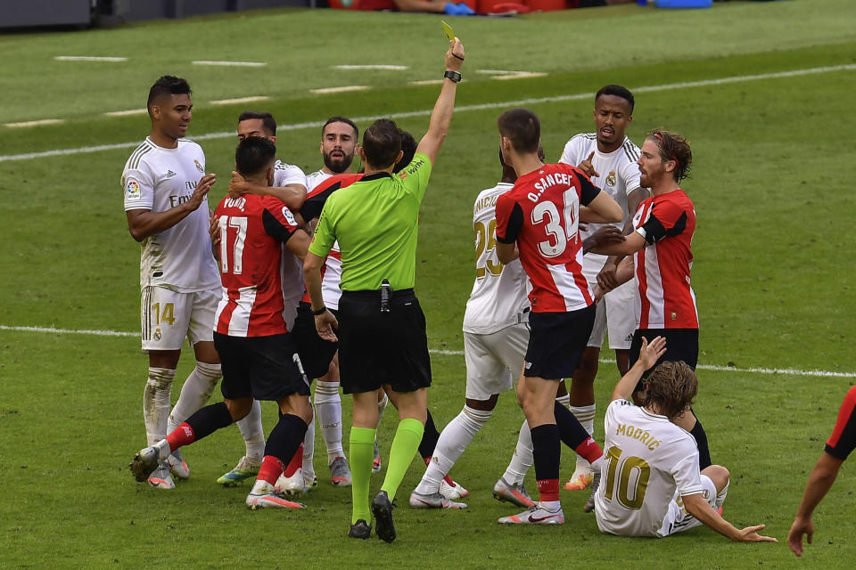 Jugadores del Athletic Bilbao y Real Madrid forcejean durante el partido de la Liga de España en Bilbao, el domingo 5 de julio de 2020. (AP Foto/Alvaro Barrientos)