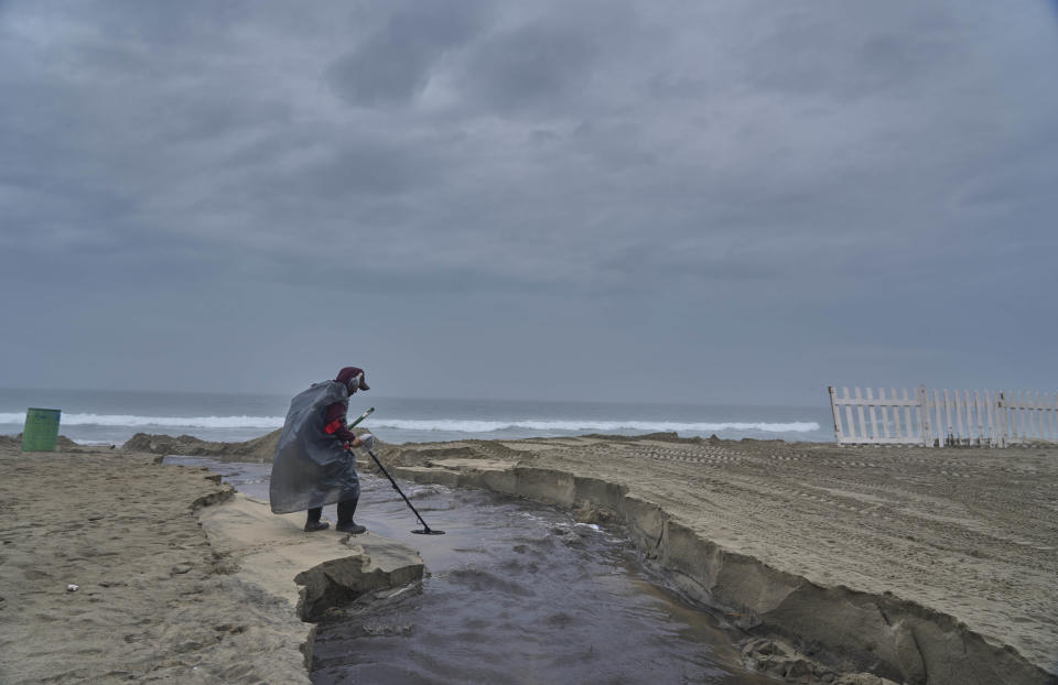 Un hombre revisa la playa con un detector de metales luego del paso de la tormenta tropical Hilary, el domingo 20 de agosto de 2023, en Rosarito, México. (AP Foto/Alejandro Cossío)