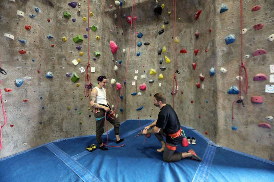 Managers Miri Dainson, left, and Will Kraemer, prepare to climb a wall at The Cliffs Climbing & Fitness, an indoor rock climbing facility in Valhalla, Oct. 26, 2023.