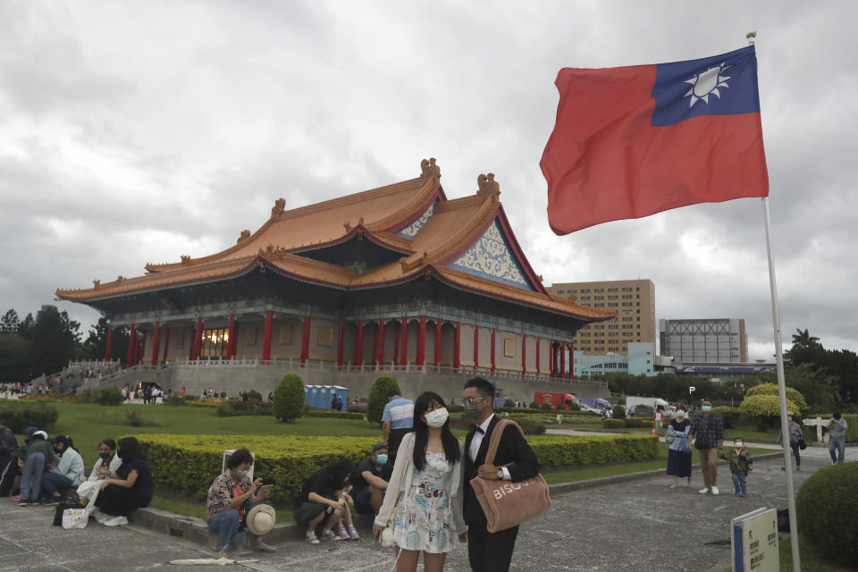 FILE - People wearing face masks walk around the Chiang Kai-shek Memorial Hall in Taipei, Taiwan, on Oct. 9, 2022. Taiwan’s government is racing to counter China’s military, but many on the island say they don’t share the sense of threat. (AP Photo/Chiang Ying-ying, File)