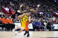 Indiana Pacers guard T.J. McConnell (9) drives as Detroit Pistons guard Marcus Sasser defends during the first half of an NBA basketball game, Wednesday, March 20, 2024, in Detroit. (AP Photo/Carlos Osorio)