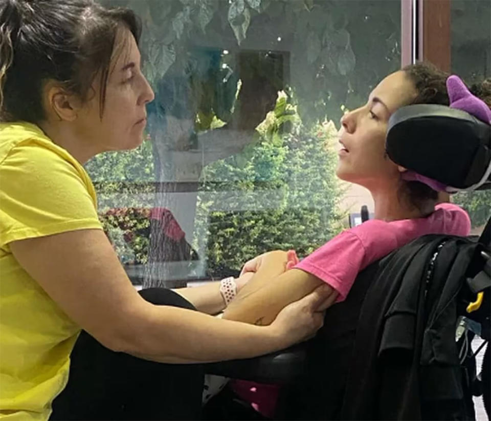 Marta in a wheelchair and unable to speak with her mum in hospital.