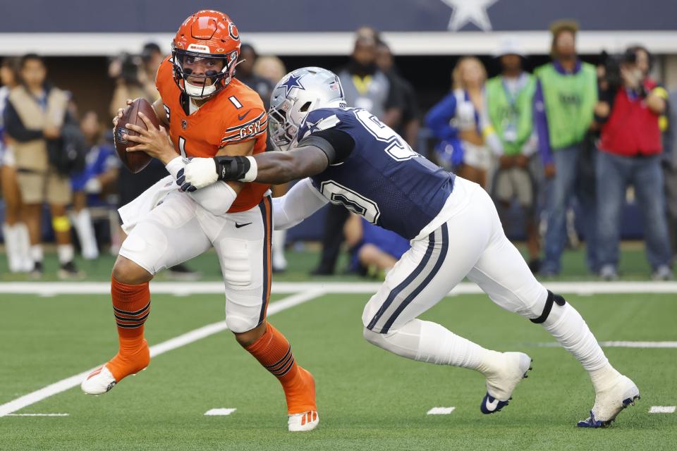 Dallas Cowboys' DeMarcus Lawrence tries to stop Chicago Bears' Justin Fields during the first half of an NFL football game Sunday, Oct. 30, 2022, in Arlington, Texas. (AP Photo/Michael Ainsworth)