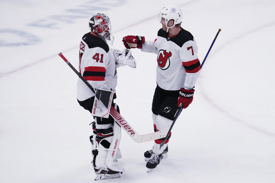 New Jersey Devils goaltender Vitek Vanecek, left, celebrates with defenseman Dougie Hamilton, right, after they defeated the Chicago Blackhawks in an NHL hockey game in Chicago, Sunday, Nov. 5, 2023. (AP Photo/Nam Y. Huh)