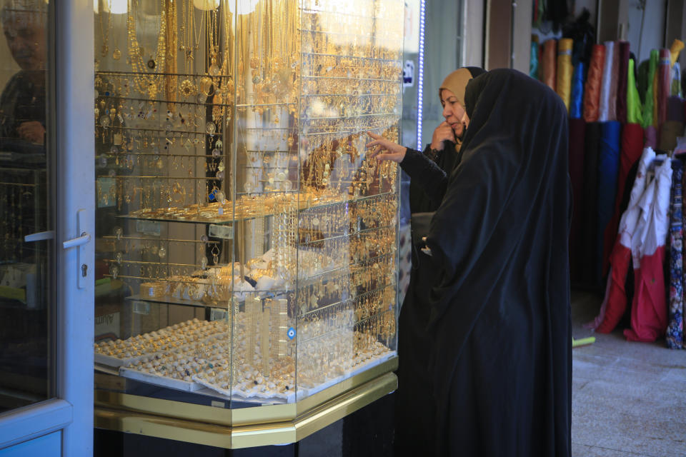 In this Jan. 18, 2019 photo, two women look at gold jewelry in the northern Iraqi town of Bartella, Iraq. Two years after it was liberated from Islamic State militants, only a fraction of Christian residents have returned to Bartella. Many fear intimidation by the town’s population of Shabak, a Shiite Muslim ethnic group who dominate the militias that now run Bartella. (AP Photo/Fay Abuelgasim)