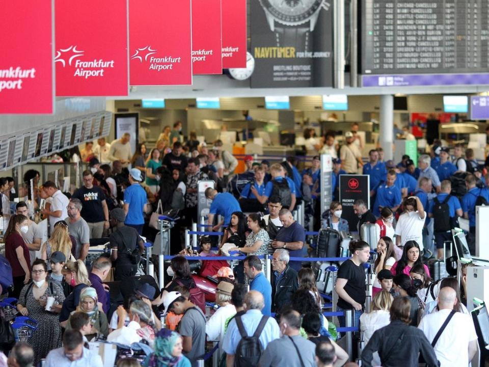 Passengers wait at counters at Frankfurt Airport after employees of German airline Lufthansa were called to strike.