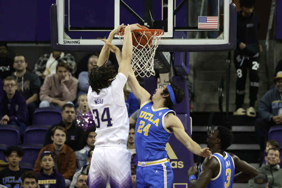 Washington guard Noah Williams dunks over UCLA guard Jaime Jaquez Jr. during the first half of an NCAA collage basketball game, Sunday, Jan. 1, 2023, in Seattle. (AP Photo/John Froschauer)