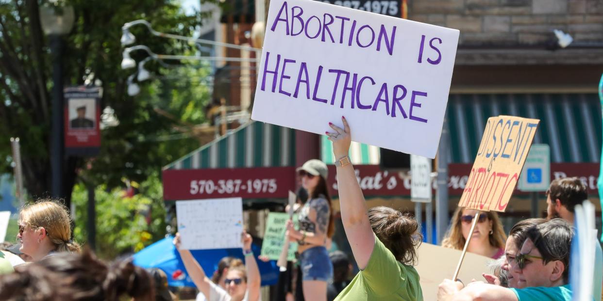 woman holding sign at protest that says "abortion is healthcare"