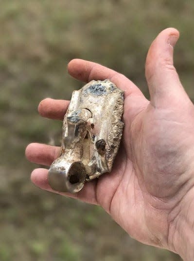 Sanford High School teacher and Sanford-Springvale Historical Society member Paul Auger displays a piece of casket hardware unearthed among skeletal remains at the site of the former Emerson School playground.