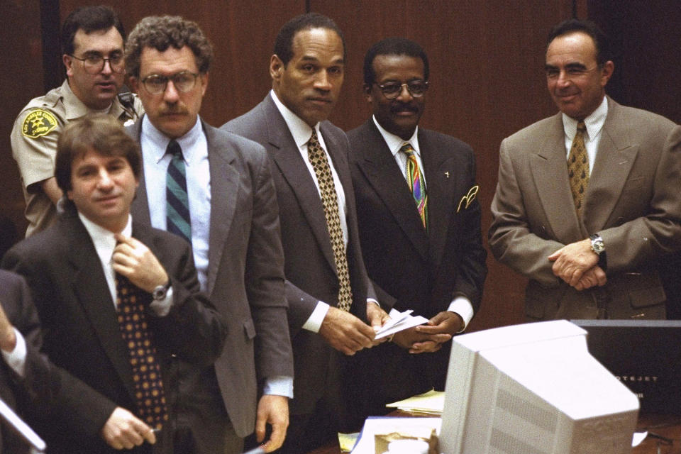 ARCHIVO-O.J. Simpson y miembros de su equipo de defensa reaccionan mientras el jurado, muchos de ellos vestidos con camisetas blancas con el lema de una cadena de pizzerías local, ingresan a la sala del tribunal en Los Ángeles el viernes 5 de mayo de 1995. De izquierda a derecha Barry Scheck, Peter Neufeld, O.J. Simpson, Johnnie Cochran Jr. y Robert Shapiro. El fondo está el oficial Guy Magnera. O.J. Simpson, el laureado astro del fútbol americano y actor de Hollywood que fue absuelto de los cargos de doble asesinato de su exesposa y su amigo, pero luego declarado responsable en un juicio civil aparte, ha fallecido. Tenía 76 años. (Foto AP/Reed Saxon, Pool, archivo)