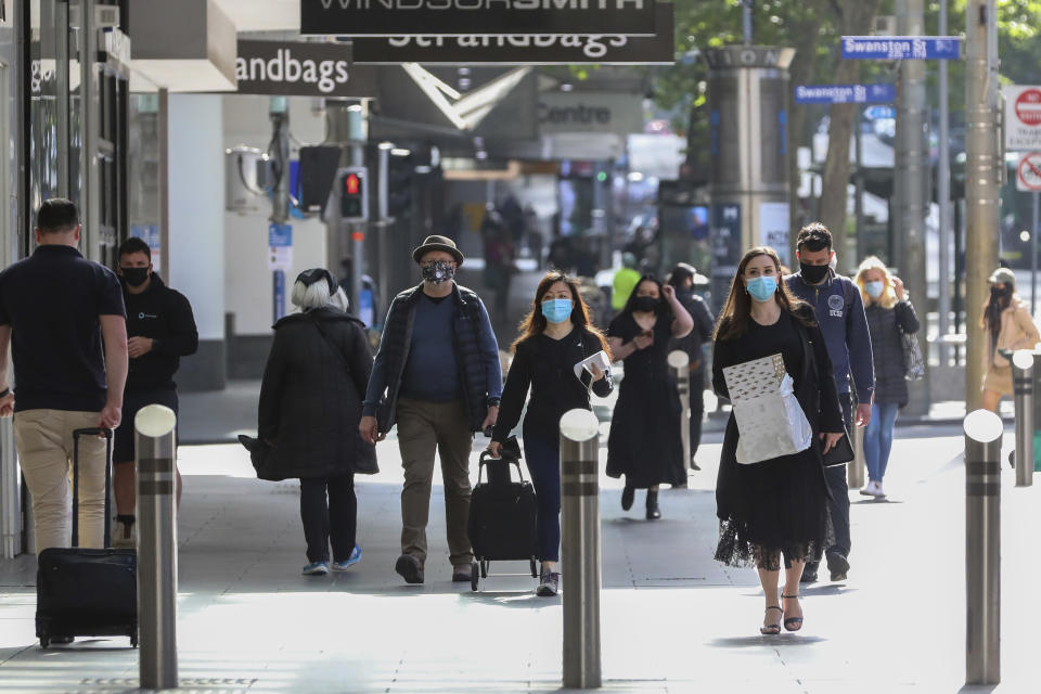 People walk through the Bourke Street Shopping mall in Melbourne, Australia, Wednesday, Oct. 28, 2020. Australia’s second largest city of Melbourne which was a coronavirus hotspot emerges from a nearly four-months lockdown, with restaurants, cafes and bars opening and outdoor contact sports resuming on Wednesday. (AP Photo/Asanka Brendon Ratnayake)