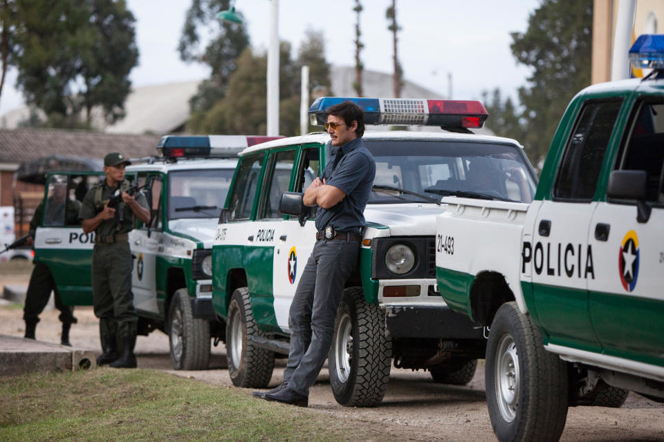 Pena leaning against a police van