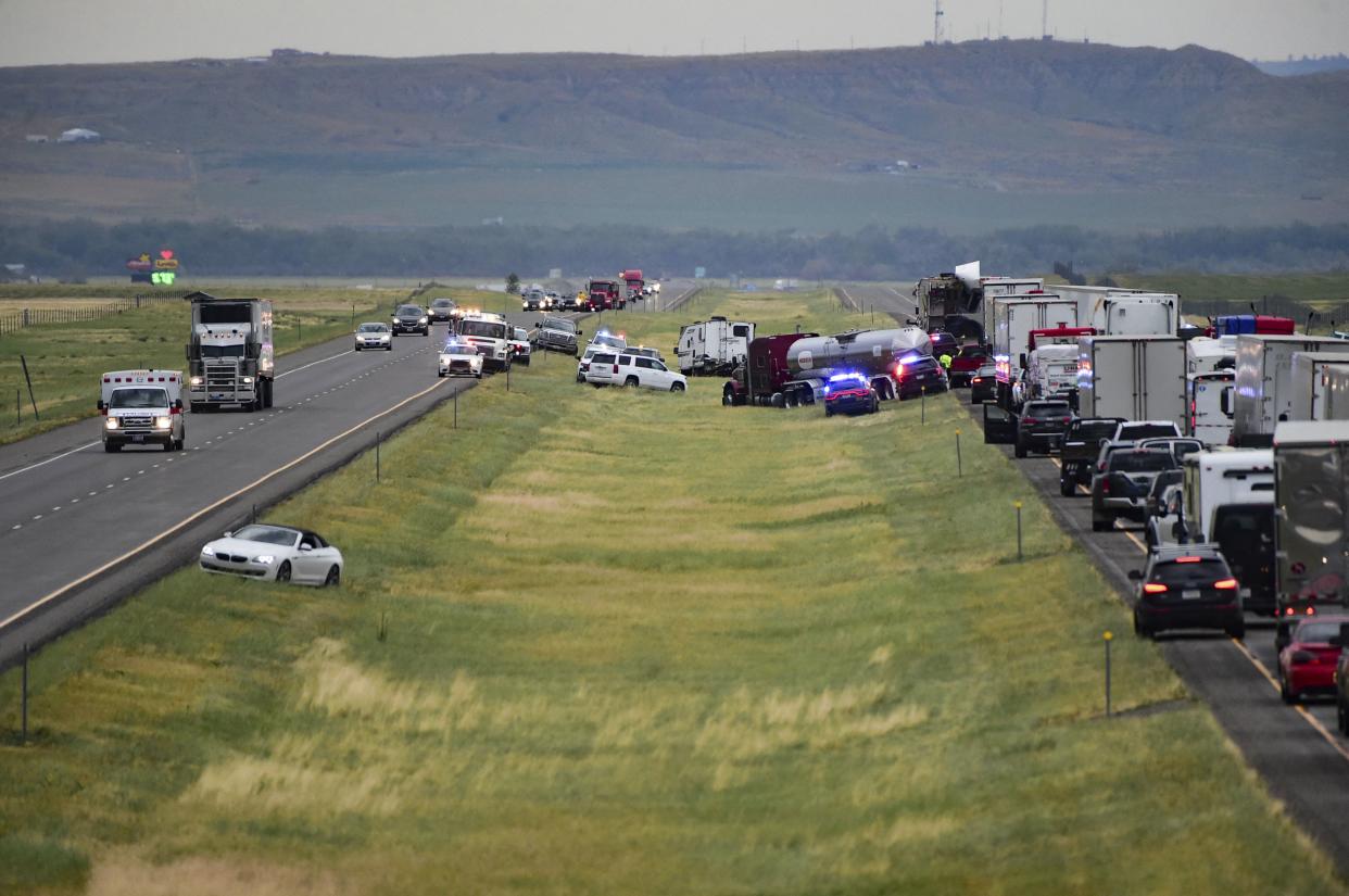 First responders work the scene on Interstate 90 after a fatal pileup where at least 20 vehicles crashed near Hardin, Mont., Friday, July 15, 2022. 