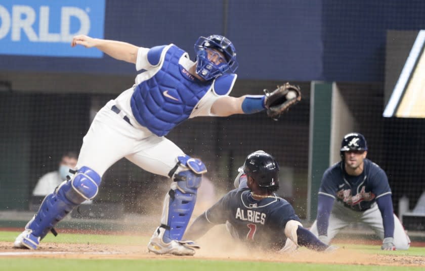 Atlanta Braves Ozzie Albies scores in the fourth inning as Dodgers catcher Will Smith is late on the tag. This is Atlanta's third run of the Game 7 of the NLCS championships.