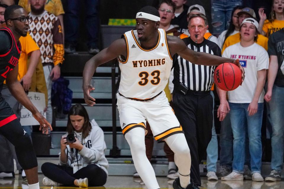 Feb 28, 2022; Laramie, Wyoming, USA; Wyoming Cowboys forward Graham Ike (33) controls the ball against San Diego State Aztecs forward Tahirou Diabate (22) during the first half at Arena-Auditorium.