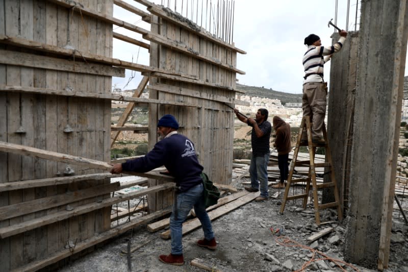 Palestinian Labourers work at a construction site in the Israeli settlement of Ramat Givat Zeev in the Israeli-occupied West Bank