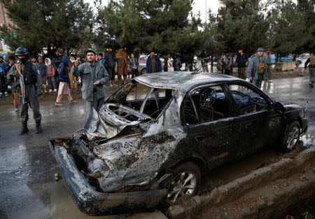 People look on at a damaged vehicle after a suicide bomb attack in Kabul, Afghanistan November 16, 2017. REUTERS/Mohammad Ismail