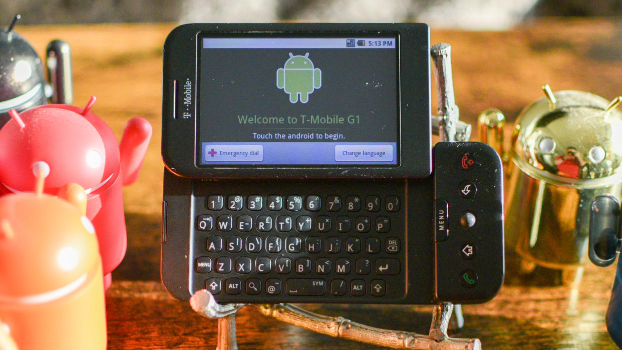  T-Mobile G1 phone with Android vinyl figurines. 