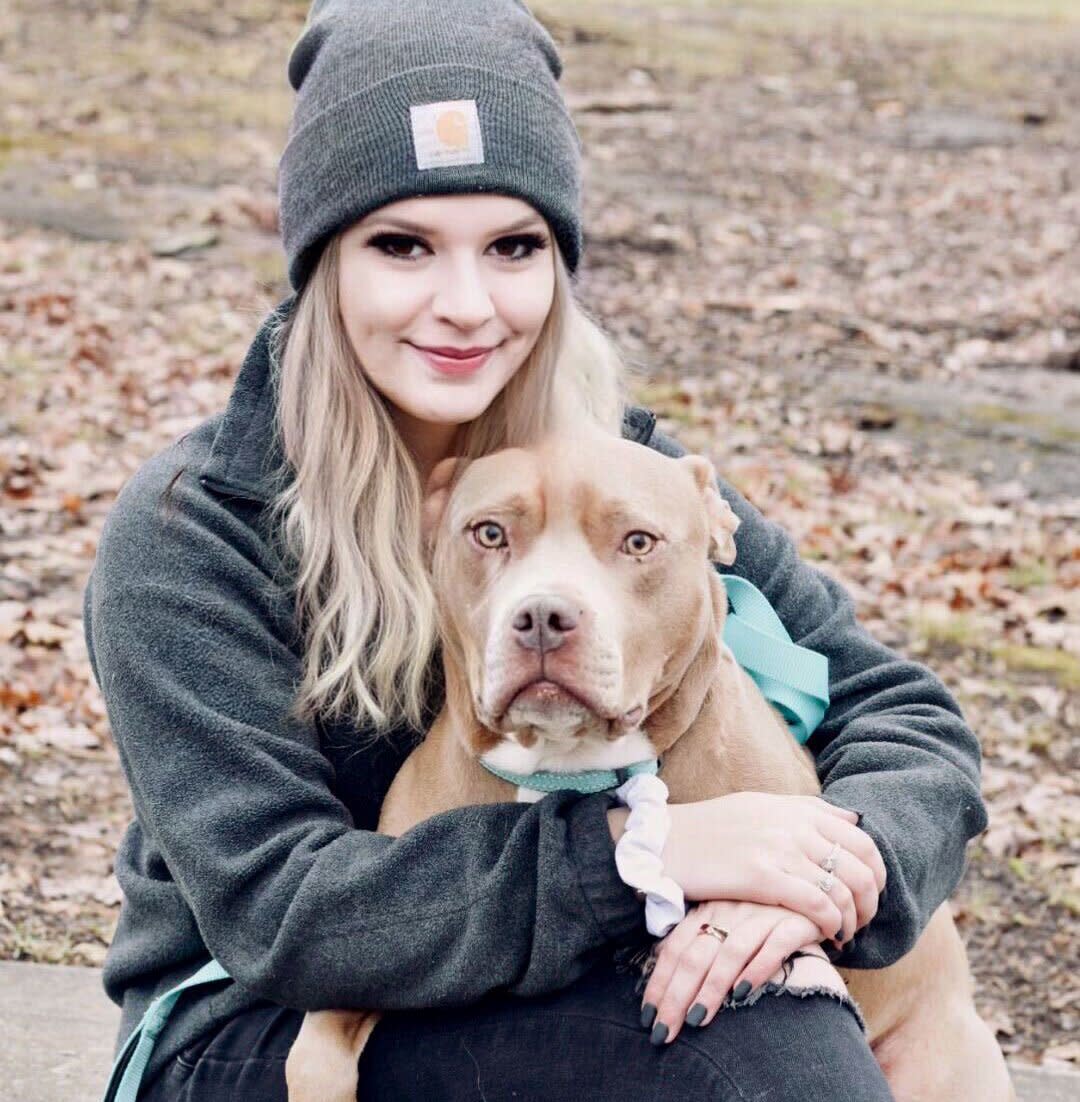 woman sitting with pit bull she reunited with after 2 years