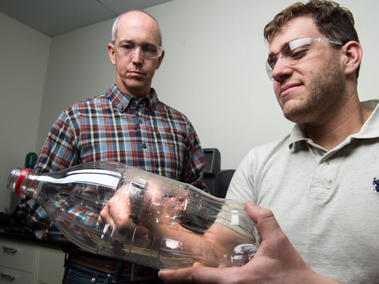 Scientists Bryon Donohoe and Nic Rorrer taking samples from a PET bottle as part of their investigation into plastic-eating enzymes: Dennis Schroeder/NREL