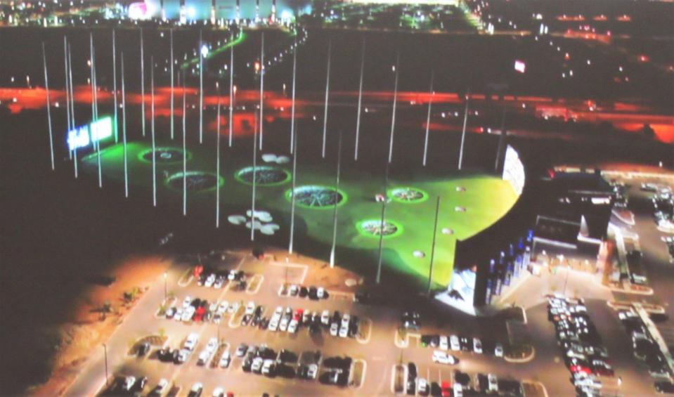 A depiction of the Topgolf site on Outlet Drive shows the lighted driving range during evening hours; the main building to the right will hold restaurants, bars and game areas.