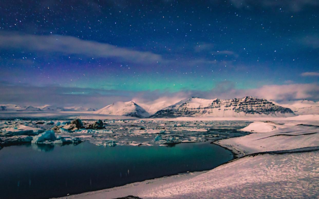 Snowcapped mountains near Reykjavik at night  - Getty