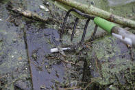 <p>Activist Rocky Morrison, of the “Clean River Project” uses a rake to reach for a discarded hypodermic needle while examining a boom filled with waste collected from a recovery boat on the Merrimack River in Chelmsford, Mass. In Portland, Maine, officials have collected more than 700 needles so far this year, putting them on track to handily exceed the nearly 900 gathered in all of 2016. In March alone, San Francisco collected more than 13,000 syringes, compared with only about 2,900 the same month in 2016. (Photo: Charles Krupa/AP) </p>