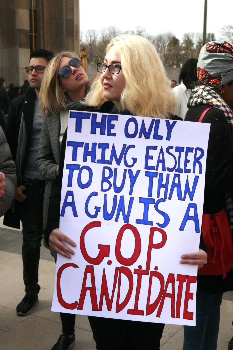 <p>A young woman holds a sign at a gathering in Paris. (Photo: Getty Images) </p>