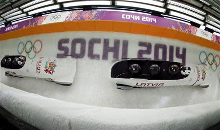 Latvia's pilot Oskars Melbardis (front) and his teammates speed down the track during a four-man bobsleigh training event at the Sanki Sliding Center in Rosa Khutor, during the Sochi 2014 Winter Olympics February 19, 2014. Picture taken using multiple exposure. REUTERS/Fabrizio Bensch