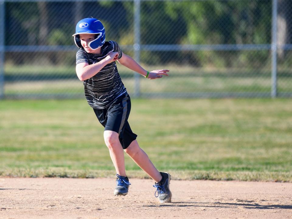 Owen Rempp (#27) runs to second base during Little League practice on Monday, August 1, 2022, at Cherry Rock Park in Sioux Falls.