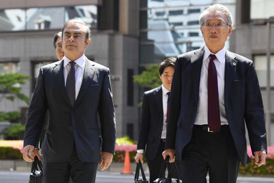 FILE - In this May 23, 2019, file photo, former Nissan chairman Carlos Ghosn, left, accompanied by his lawyer Junichiro Hironaka, arrives at Tokyo District Court for a pre-trial meeting in Tokyo. Lawyers for Ghosn, who is awaiting trial in Japan, asked the court on Thursday, Oct. 24, 2019, to dismiss all charges filed against him in his financial misconduct case. The papers his lawyers filed in the court allege prosecutorial misconduct will prevent Ghosn from having a fair trial. The fillings allege unlawful collusion between the prosecutors, government officials and executives at Nissan Motor Co. drummed up allegations of wrongdoing to remove him as chairman. (Ren Onuma/Kyodo News via AP, File)