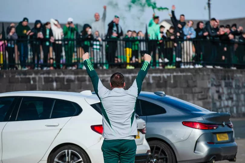 Brendan Rodgers salutes the waiting crowd as the champions are cheered onto the team bus.