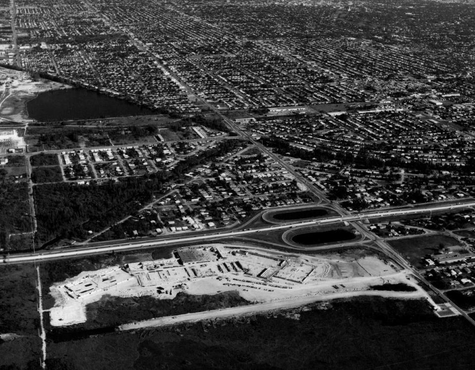 The foundations are in place as buildings rise at Midway Mall, the enclosed, air-conditioned multi­million dollar shopping center complex located at the intersection of Flagler Street and the Palmetto bypass in this 1970 file photo. The mall, designed by architects-engineers Mort Fellman and Don Reiff, was being developed by veteran shopping center developers Edward M. Strawgate and Herbert Sadkin. The mall had a distinct boomerang shape, as can be seen in this aerial photo. Scheduled for a late 1970 completion, Midway Mall will feature three major department stores, including Richards, Woolco, and J. B. Hunter. It will also have 70 other service and specialty shops. Utilizing the services of more than 400 construction workers a day, it will be the largest single commercial construction project in Dade County for 1970.