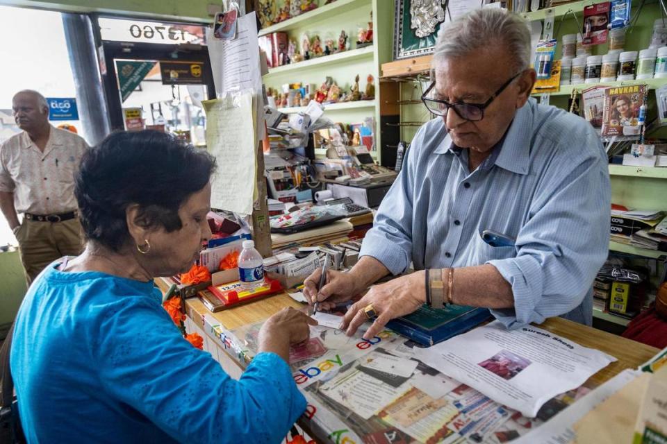 Suresh Sheth, right, takes care of long time customer Nirmala Prakash , left, at the counter of the Indo American Store in West Kendall. 