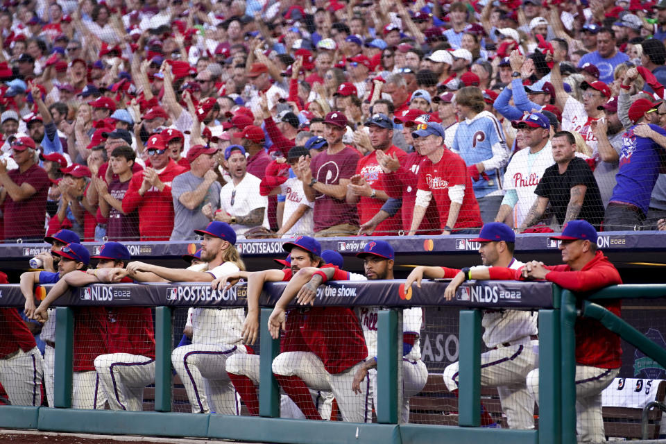 Fans cheer behind the dugout during the ninth inning in Game 4 of baseball's National League Division Series between the Philadelphia Phillies and the Atlanta Braves, Saturday, Oct. 15, 2022, in Philadelphia. (AP Photo/Matt Slocum)