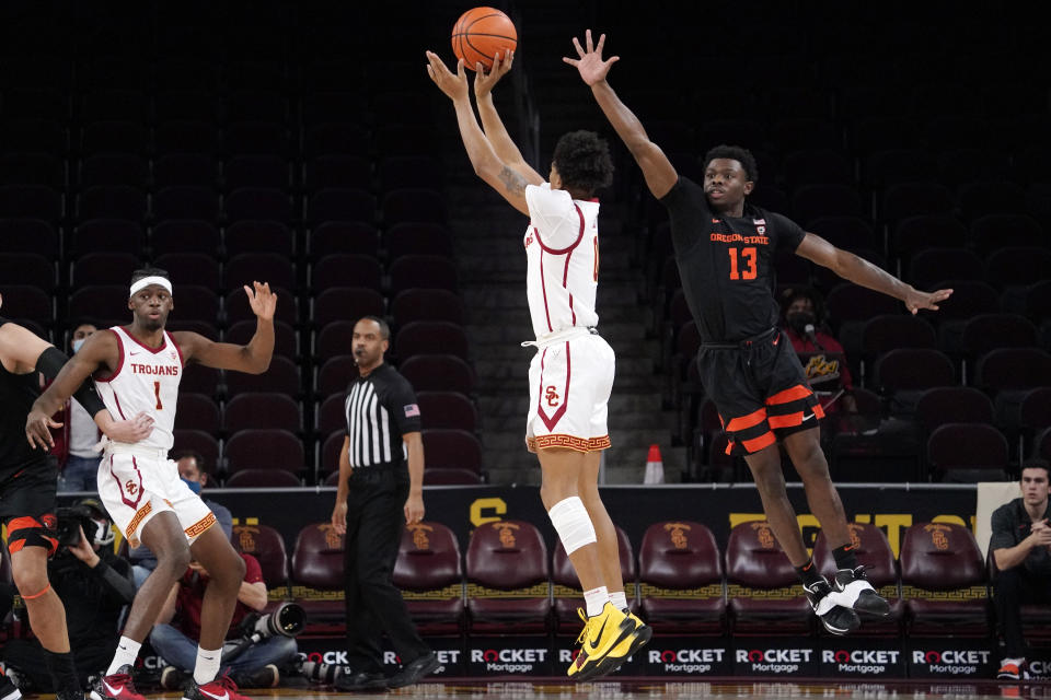 Southern California guard Boogie Ellis, center, shoots as Oregon State guard Dashawn Davis, right, defends during the first half of an NCAA college basketball game Thursday, Jan. 13, 2022, in Los Angeles. (AP Photo/Mark J. Terrill)