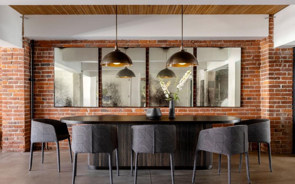 A dining room with mirror above the dining table