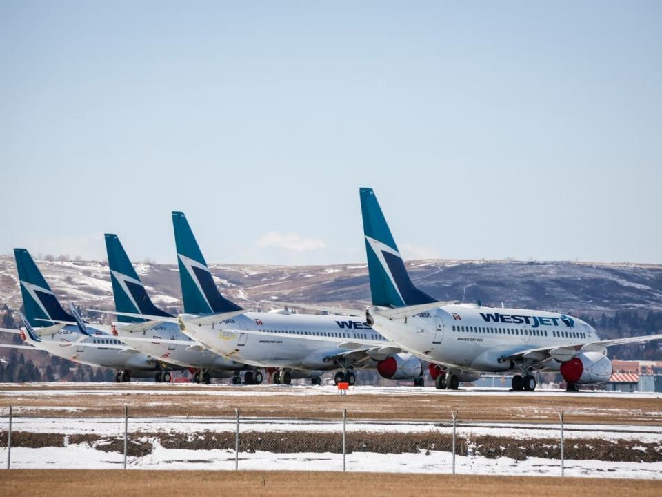 WestJet planes parked at the Calgary Airport in March 2020. Nav Canada, the navigation system operator at the airport, experienced a system outage Thursday, and WestJet's check-in system had some intermittent issues. (Jeff McIntosh/The Canadian Press - image credit)