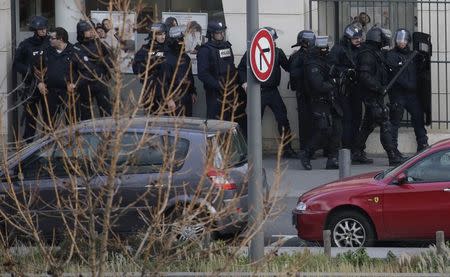 Members of the French police forces secure the area next to the post office in Colombes outside Paris, were an armed gunman is holding hostages January 16, 2015. REUTERS/Philippe Wojazer