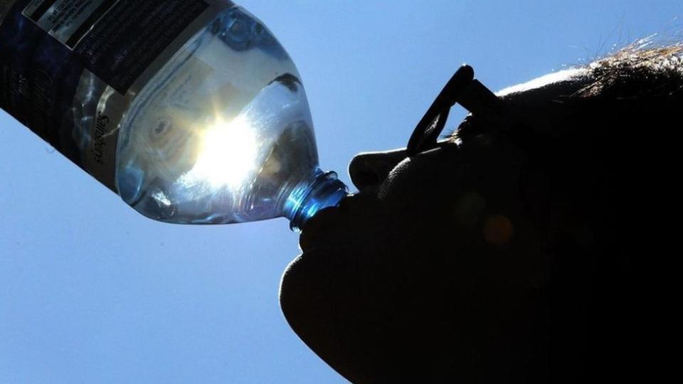 Mujer bebiendo una botella de agua.