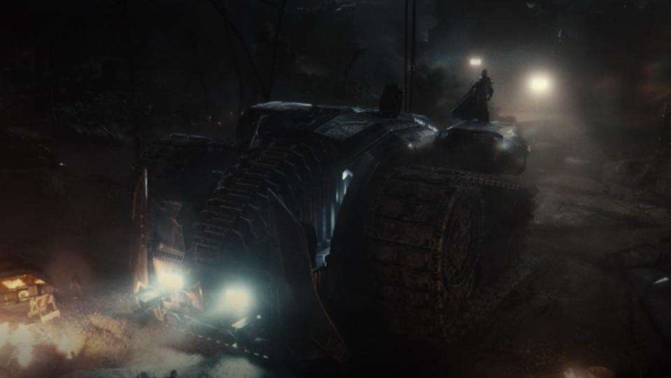 Batman stands on a giant Bat tank